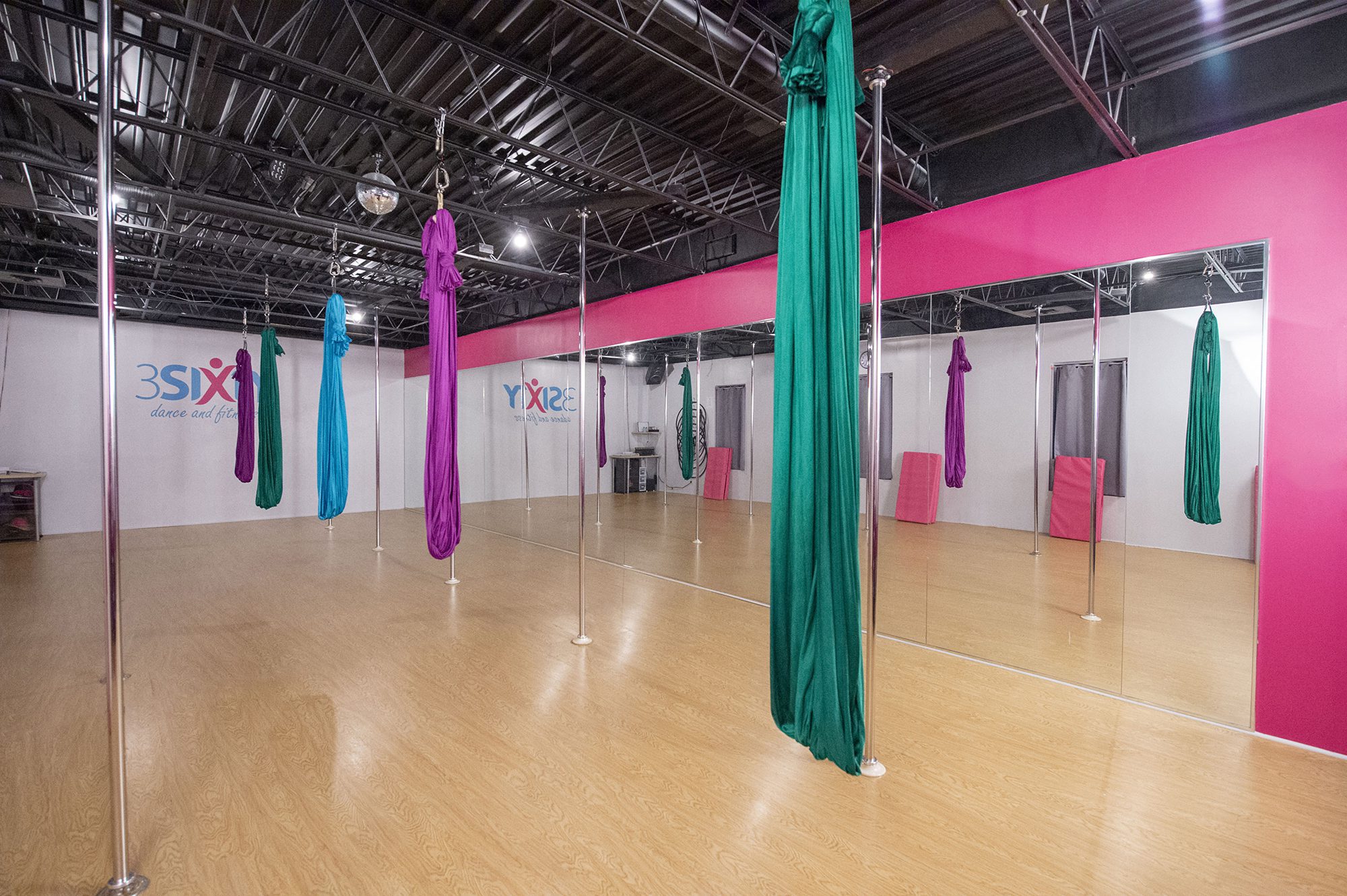 The aerial room at 3Sixty's Clyde studio, with aerial silks rigged over a wooden floor
